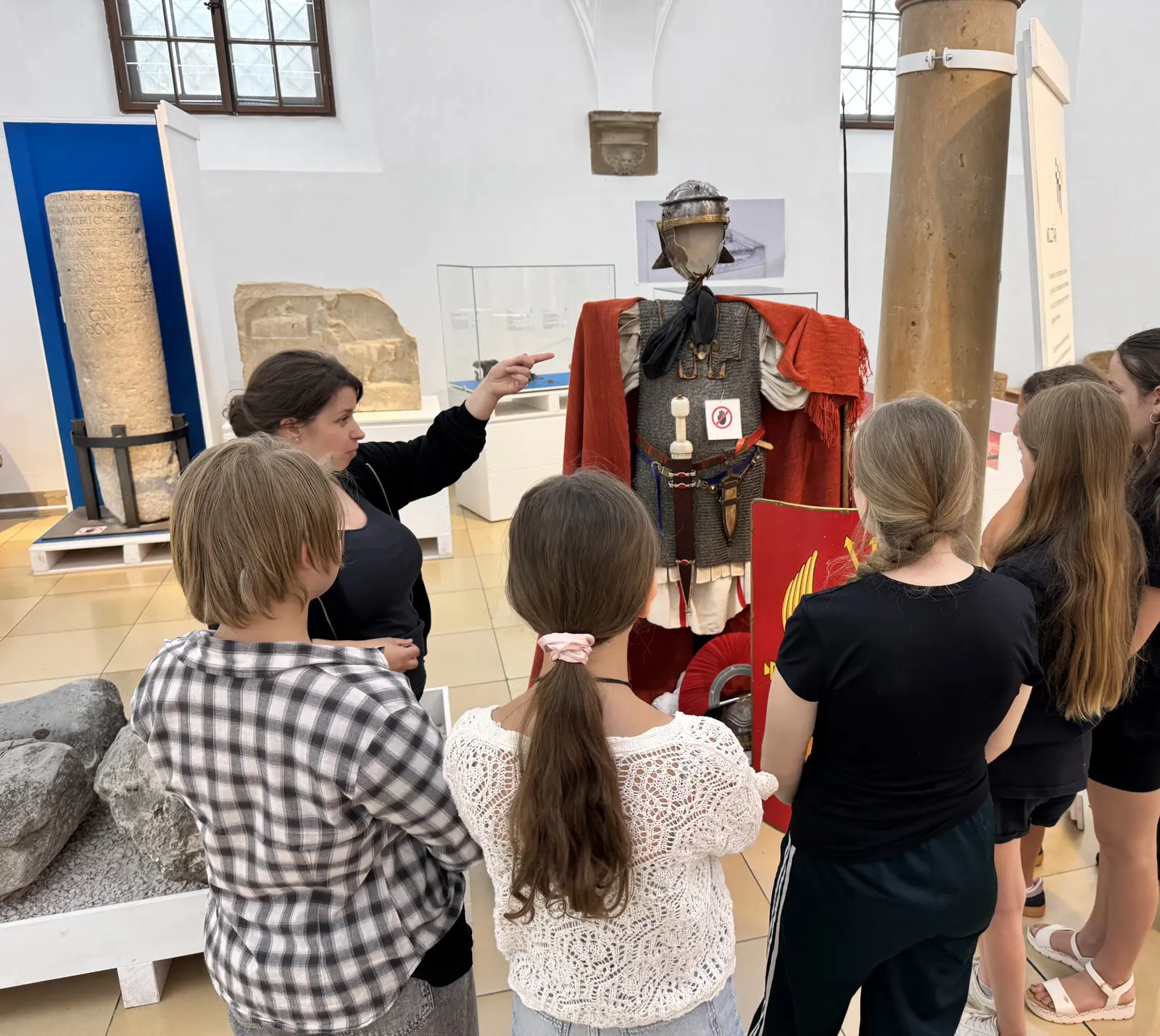 Eine Schülergruppe betrachtet beim Ausflug ins Römische Museum eine römische Rüstung